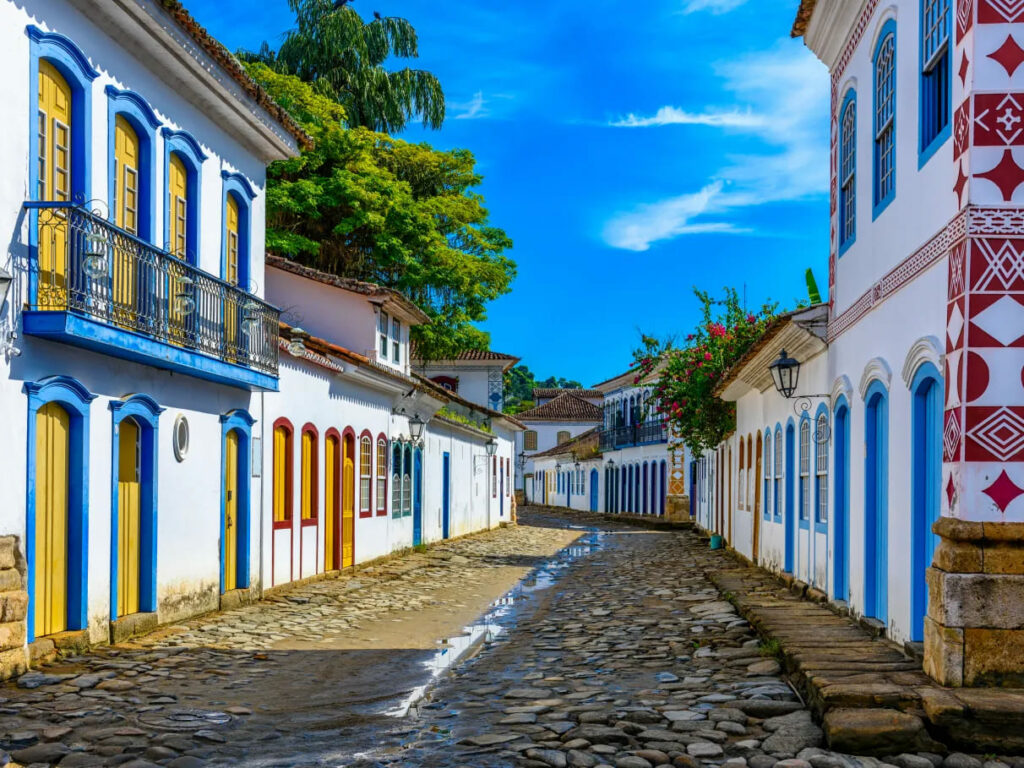 Rua de pedra charmosa no centro histórico de Paraty, Rio de Janeiro, com casarões coloniais coloridos e portas e janelas vibrantes, perfeito para um passeio romântico.