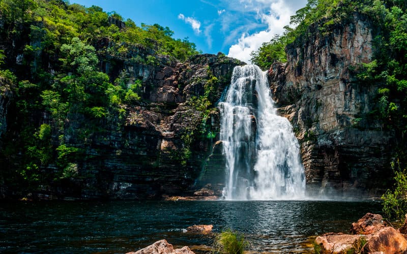 Cachoeira imponente na Chapada dos Veadeiros, Goiás, com águas cristalinas e rochas avermelhadas, ideal para casais que buscam natureza e conexão.