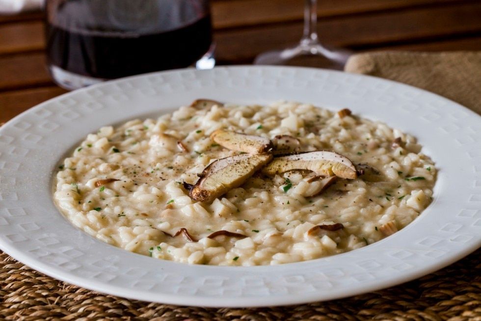 Risoto de funghi porcini com um copo de vinho tinto. para um jantar italiano em casa